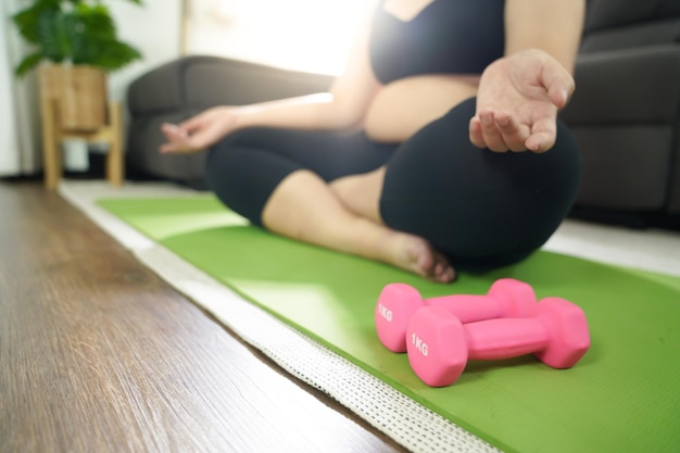 Overgewicht vrouw trainen voor gewichtsverlies oefening met halters in stretch posities thuis in de woonkamer Vrolijke dikke vrouw dieet gezonde levensstijl concept