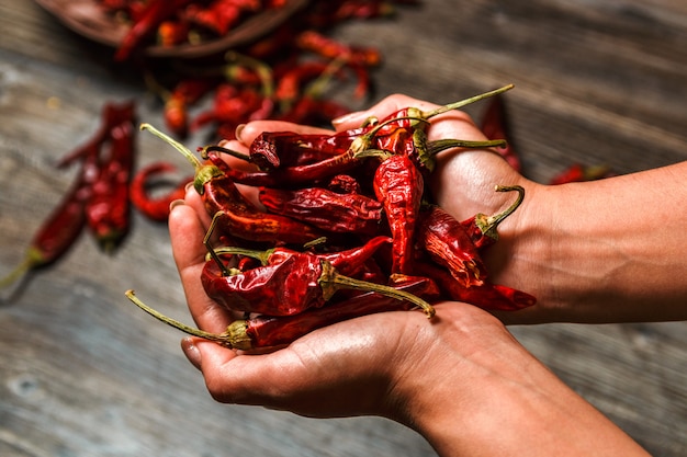 Overhandigt de close-up droge Mexicaanse Spaanse peper binnen een houten lijst