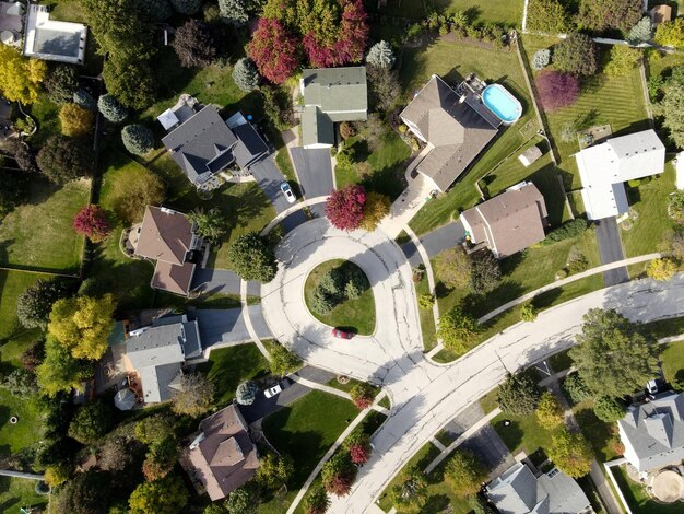 Photo overhead aerial view of colorful autumn trees residential houses and yards along suburban street