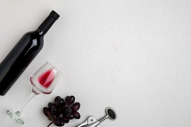 Photo overhead angled view of a large bottle of red wine drinking glass on white background