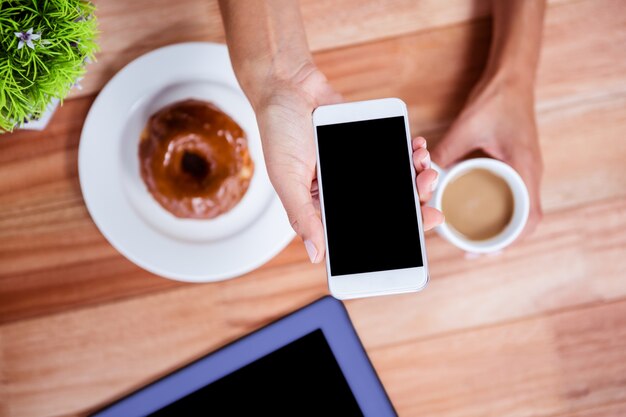 Overhead of feminine hand using smartphone