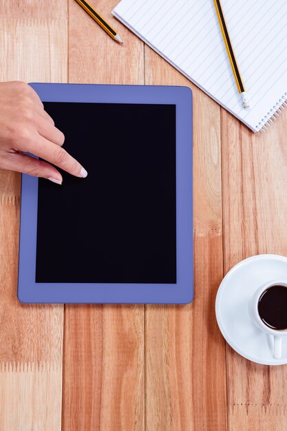 Overhead of feminine hand using tablet