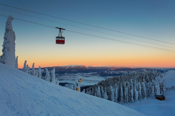 Foto overhead kabelbaan op sneeuw bedekt landschap tegen de hemel tijdens de zonsondergang