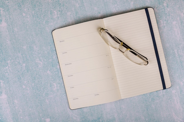 Overhead of notepad and Glasses on a desk