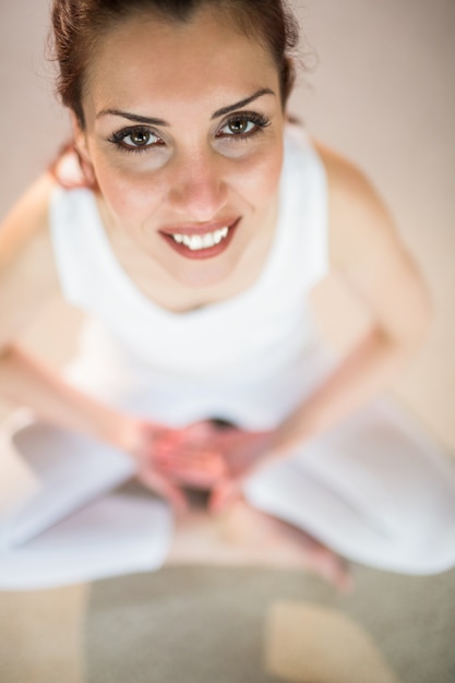 Foto ritratto sopraelevato della donna sorridente nella posa di yoga