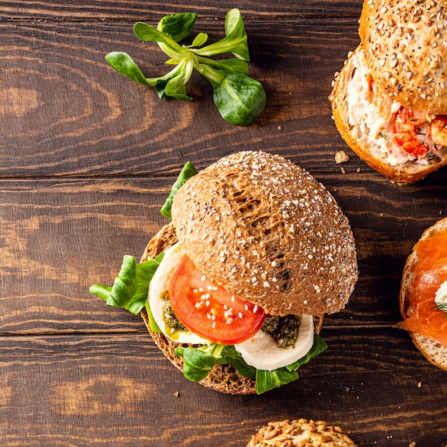 Overhead shoot with assorted sandwiches on wooden surface. Healthy food concept with copy space. Top view