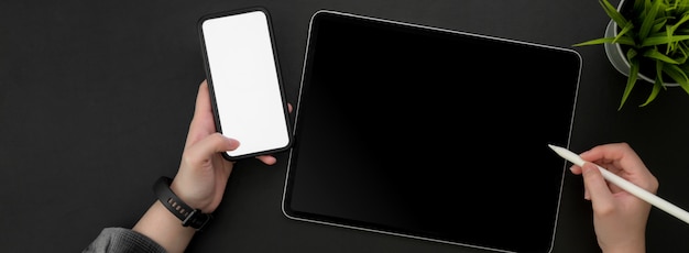 스타일러스 펜 및 모형 스마트 폰 디지털 태블릿에서 작업하는 여성 프리랜서의 오버 헤드 샷