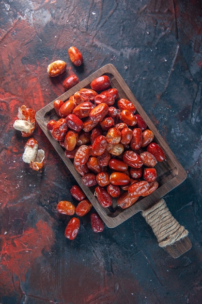 Overhead shot of fresh raw silverberry fruits inside and out side of a wooden tray on mix colors background