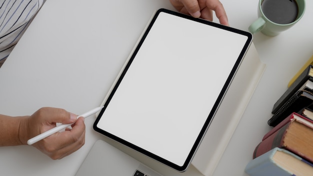 Photo overhead shot of male artist drawing on digital tablet on white desk