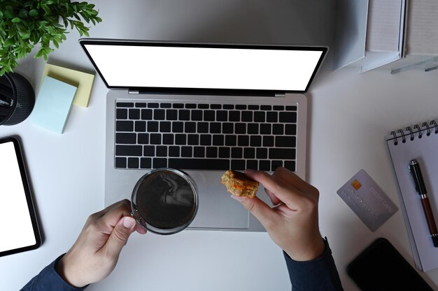 Overhead shot man drinking coffee at his workspace