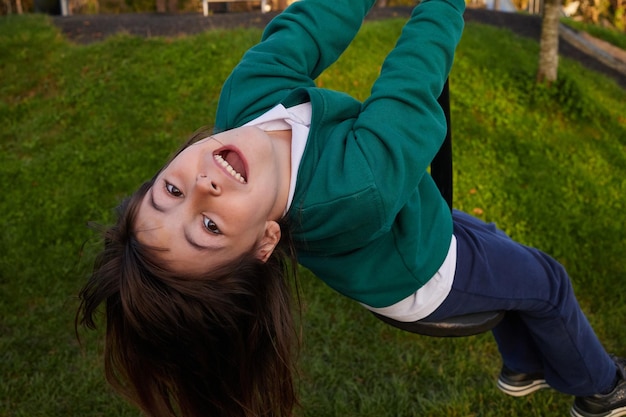 写真 学校の制服を着た5歳の女の子がロープにぶら下がっている上空の写真