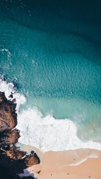 Overhead shot of refreshing deep blue ocean water and a rocky shore