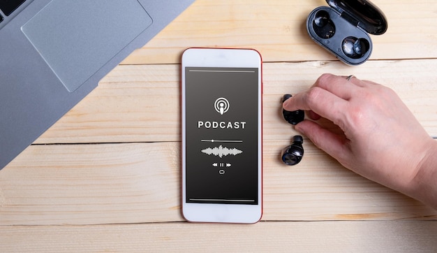 Photo overhead shot of a smartphone playing a podcast and a woman39s hand interacting podcast audience