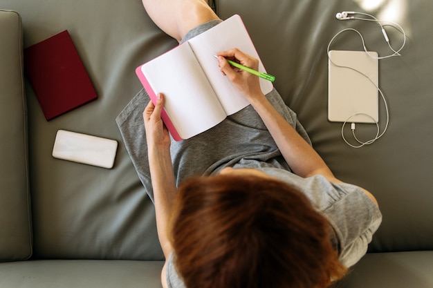 Overhead Shot On Woman Working At Notebook At Home