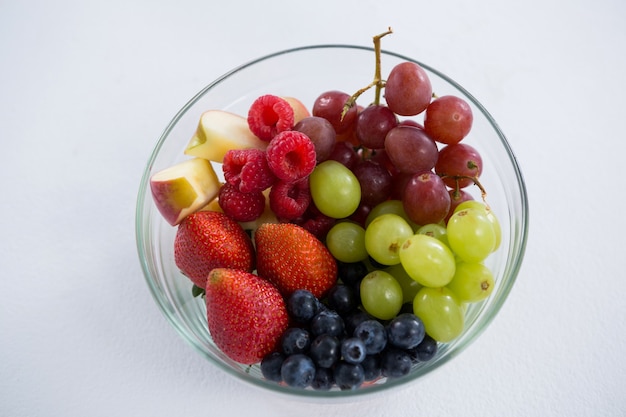 Overhead of various fruits in bowl against white background