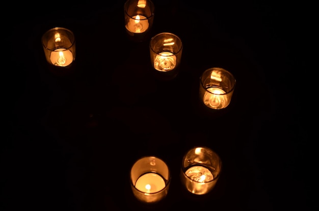 Overhead view of 6 votive candles each in glass container