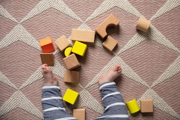 Photo overhead view of a baby playing with wooden building blocks