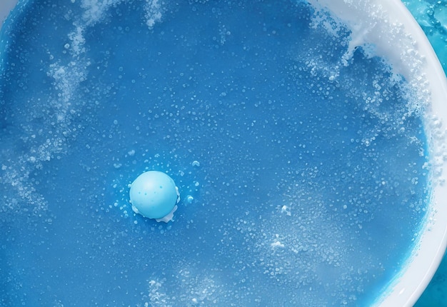 An overhead view of blue bath bomb foam in wate