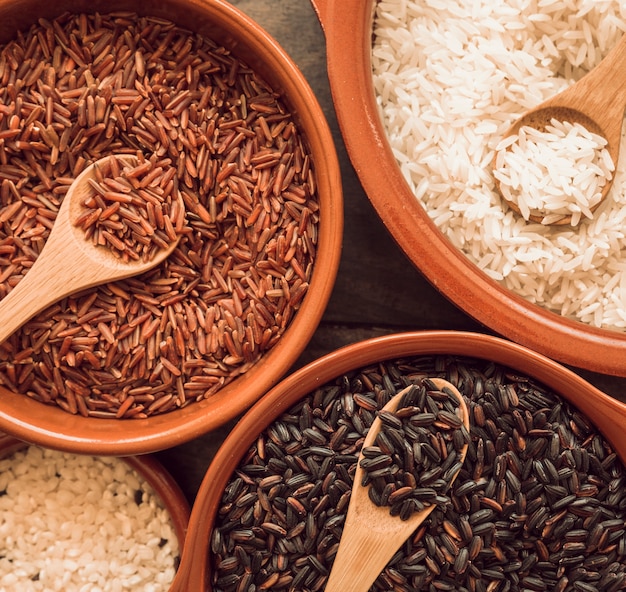 Photo overhead view of bowls with red; brown and white rice bowls