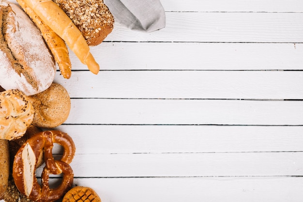 An overhead view of bread assortment on wooden plank