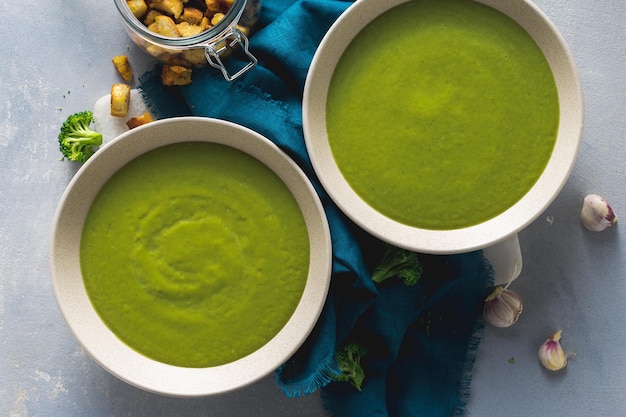 Overhead view broccoli soup in bowl with bread croutons