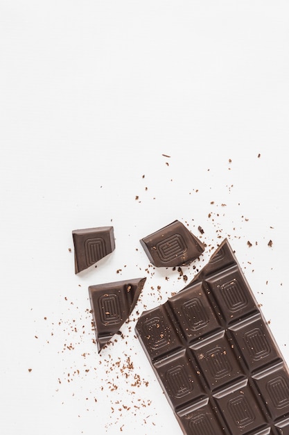 An overhead view of broken chocolate bar on white background