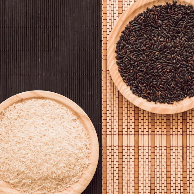 Photo overhead view of brown and white rice grains on placemat