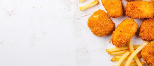 Foto vista panoramica di nuggets di pollo e cibi spazzatura in profondità sulla superficie luminosa