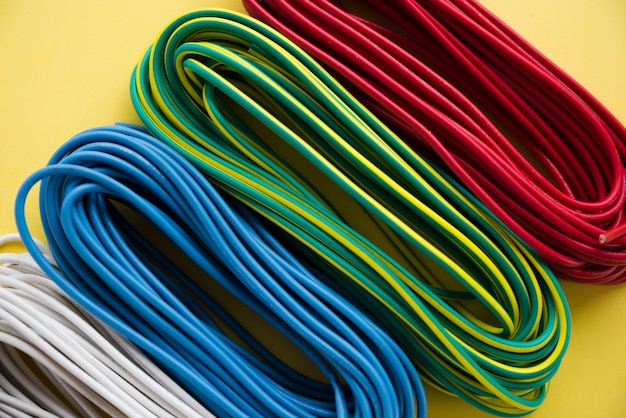Photo overhead view of colorful electric wire bundle on yellow surface