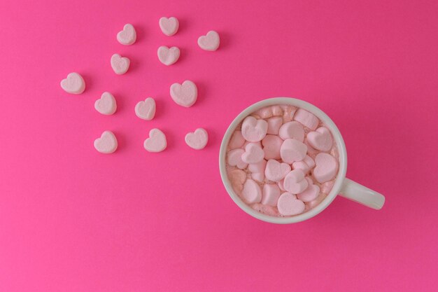 Overhead view of cup of hot cocoa with pink heart shaped marshmallows