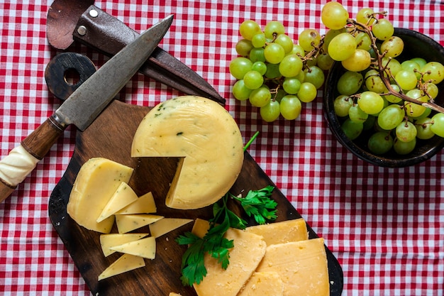 Una vista dall'alto di un delizioso piccolo pezzo di formaggio speziato e uva su un tavolo. concetto di cibo naturale, biologico e sano.