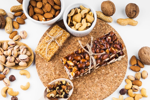 An overhead view of dried fruits and energy bar on white backdrop