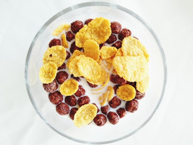 Photo overhead view of fruits and cornflakes in milk