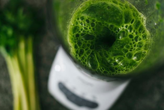 Photo overhead view of green smoothie in blender