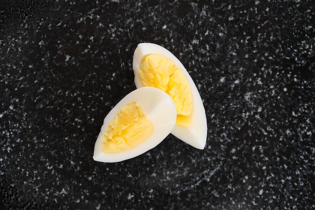 Вид сверху на половину вареного яйца, разрезанного на две части