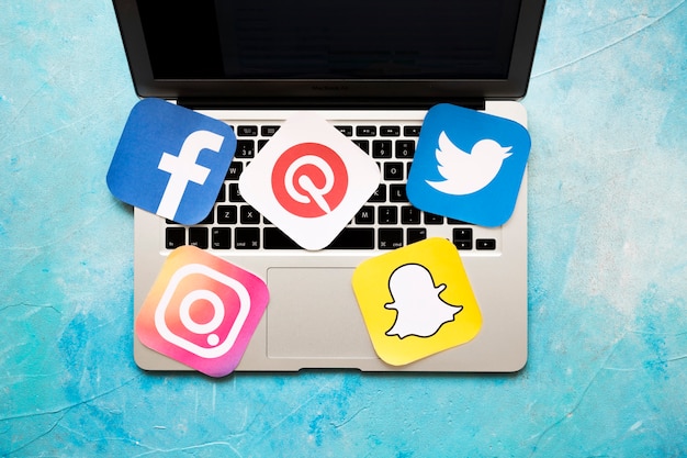 Photo overhead view of laptop with social medic icons over the blue background