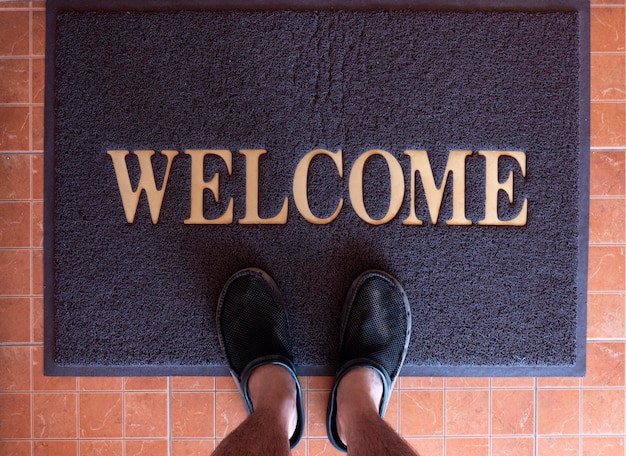 Overhead view of man standing on a welcome mat