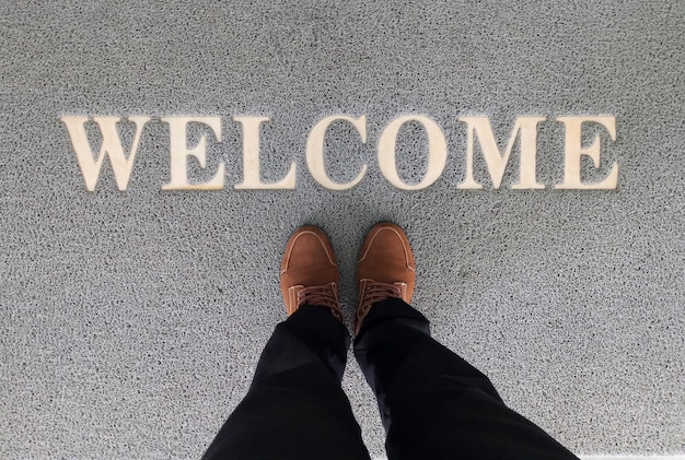 Overhead view of man standing on a welcome mat