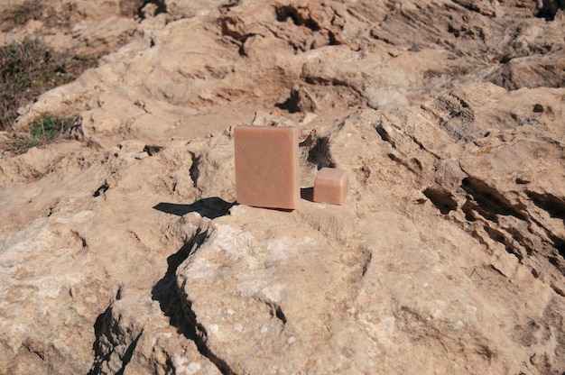 Overhead view of pink french clay soap bar at the beach with rocks