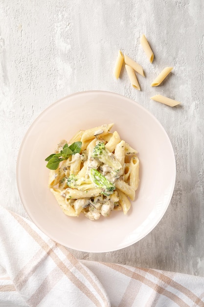 Overhead view of plate with pasta on light grey concrete background