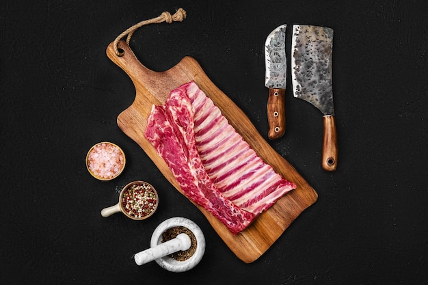 Overhead view of raw Lamb breast and flap on wooden cutting board