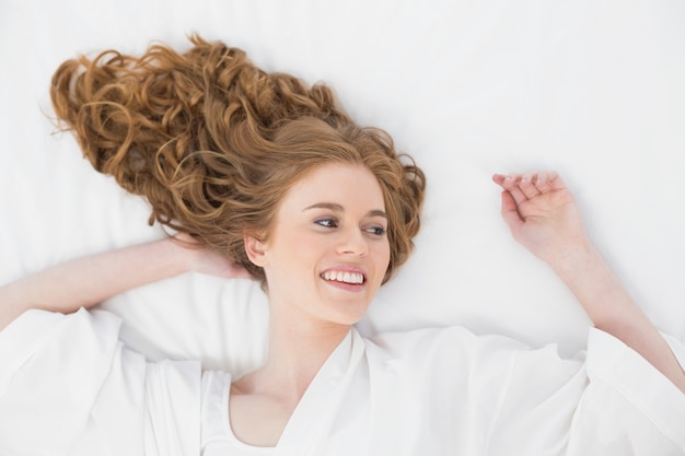 Overhead view of a smiling young blond in bed