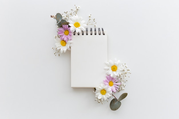 Photo overhead view of a spiral blank dairy decorated with different flowers