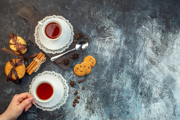 Overhead view of stacked cookies cinnamon limes on wooden cutting board and tea on ice background