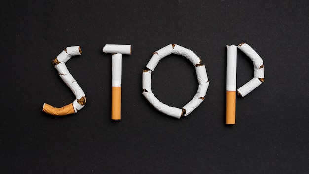 Photo overhead view of stop text made from cigarettes