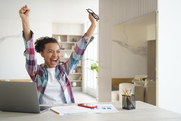 Photo overjoyed african american student teen girl got email with good exam scores celebrates success