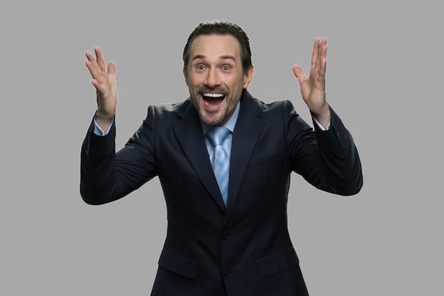 Photo overjoyed businessman expressing happiness. happy excited businessman celebrating his success. isolated on gray background.