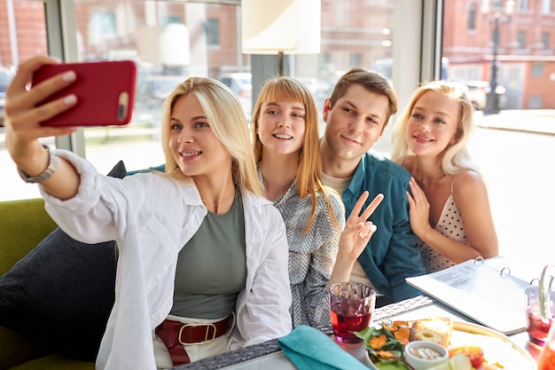 Overjoyed caucasian people posing for photo in cafe together