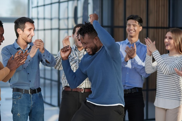 Photo overjoyed diverse businesspeople triumph have fun dancing in modern office corridor