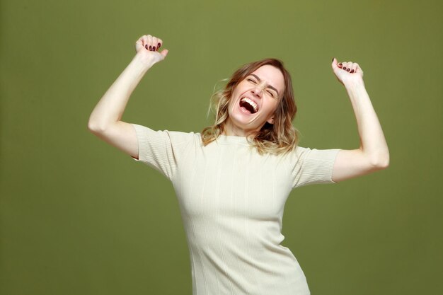 Overjoyed successful young woman celebrating win with raised arms screaming with euphoria happiness